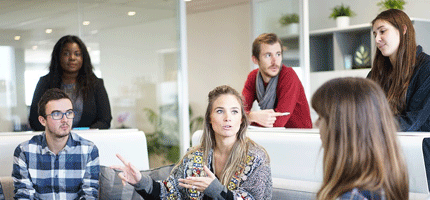 un groupe de plusieurs professionnels hommes et femmes discutent des avantages de l'alternance